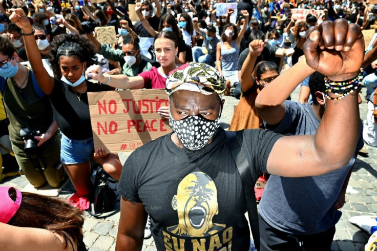 Protesters raised their fists and held 8 minutes silence in a protest in Rome