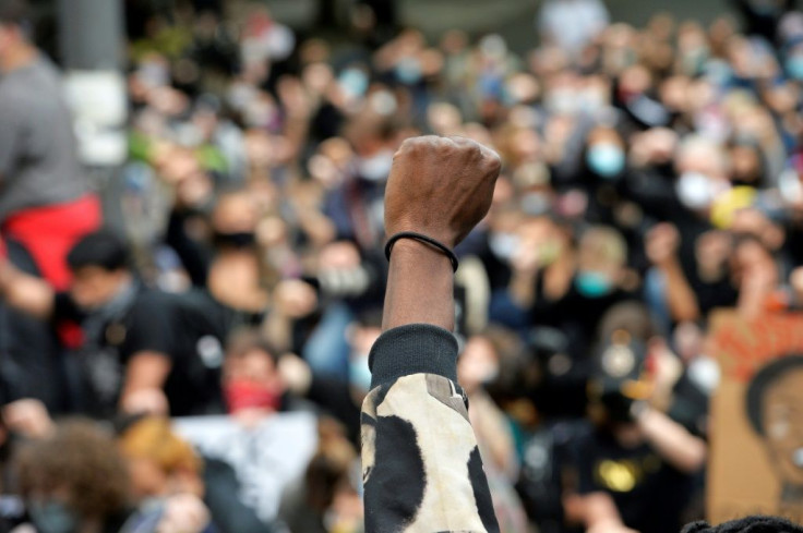 Protesters take a knee and raise their fists in a moment of silence for George Floyd and other victims of police brutality in Boston, Massachusetts