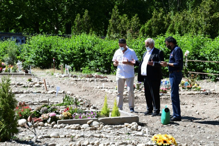 Gueddouda Boubakeur, centre, shown praying with a mourner at his wife's grave, urged "political will" to create more Muslim burial spaces