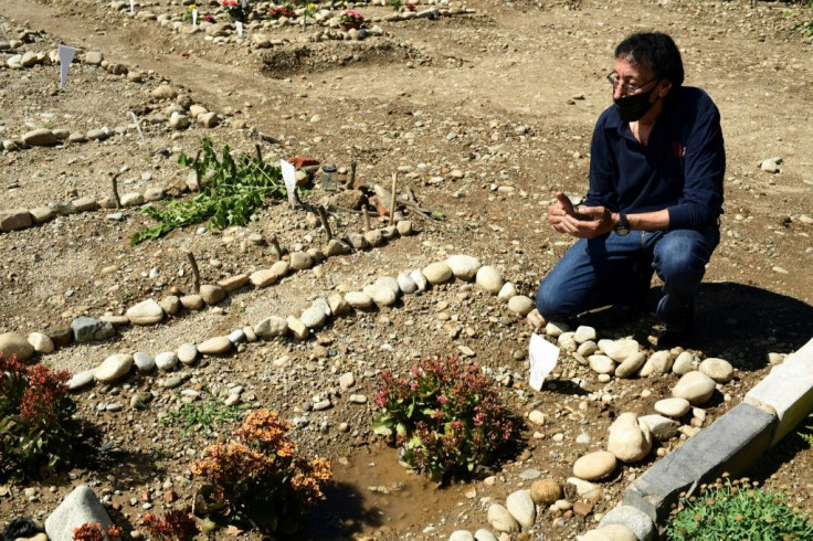 Morocco's Mustapha Moulay prays before his wife's simple grave