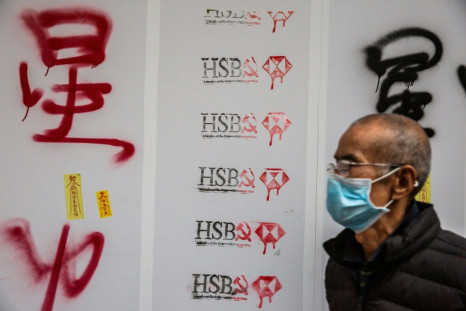 A man walks past graffiti against banking giant HSBC during a pro-democracy march in Hong Kong on January 1, 2020