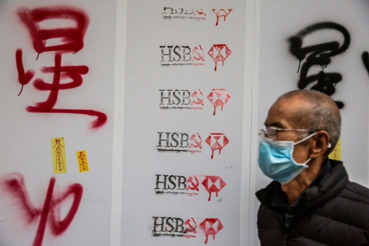 A man walks past graffiti against banking giant HSBC during a pro-democracy march in Hong Kong on January 1, 2020