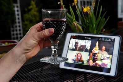 A woman lifts her glass during a virtual happy hour with friends on Zoom during the coronavirus crisis -- the video-meeting platform has soared in popularity during the pandemic