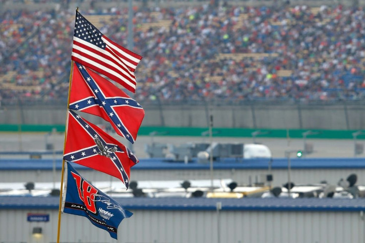 Two Confederate flags fly at Kentucky Speedway during a NASCAR race in 2015. NASCAR said Thursday it is banning the display of the flags at future events