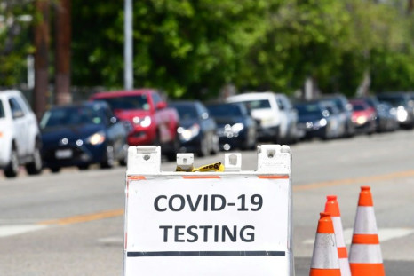 Drivers in their vehicles wait in a long line at a coronavirus testing site in Los Angeles, California