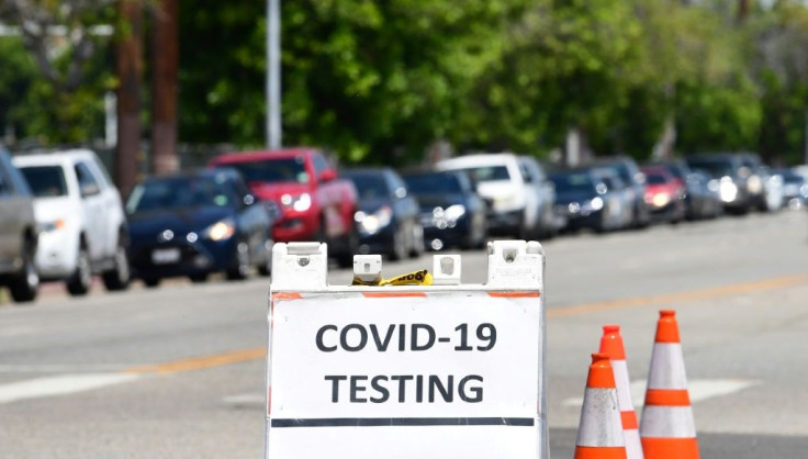 Drivers in their vehicles wait in a long line at a coronavirus testing site in Los Angeles, California