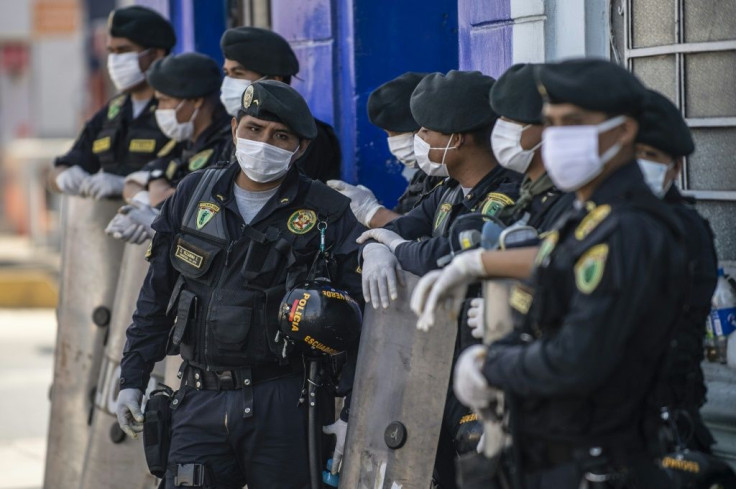 Police officers stand guard at the Caqueta market in the north of Lima -- it is believed many of those with coronavirus were infected during such patrols