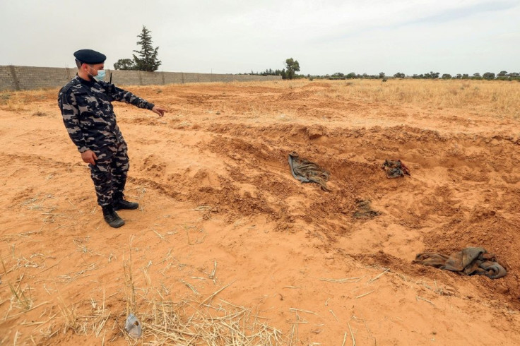 A member of security forces affiliated with the GNA's Interior Ministry surveyed the reported site of a mass grave in the town of Tarhuna, southeast of the capital Tripoli