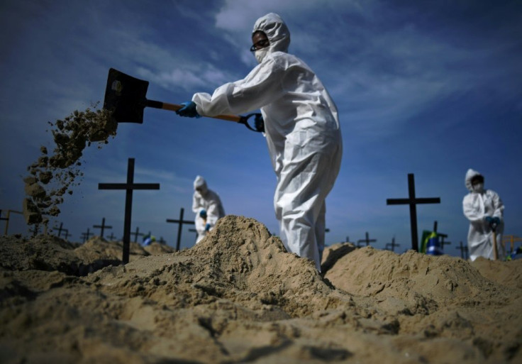 Members of the Rio de Paz NGO dig mock graves on Copacabana Beach on June 11