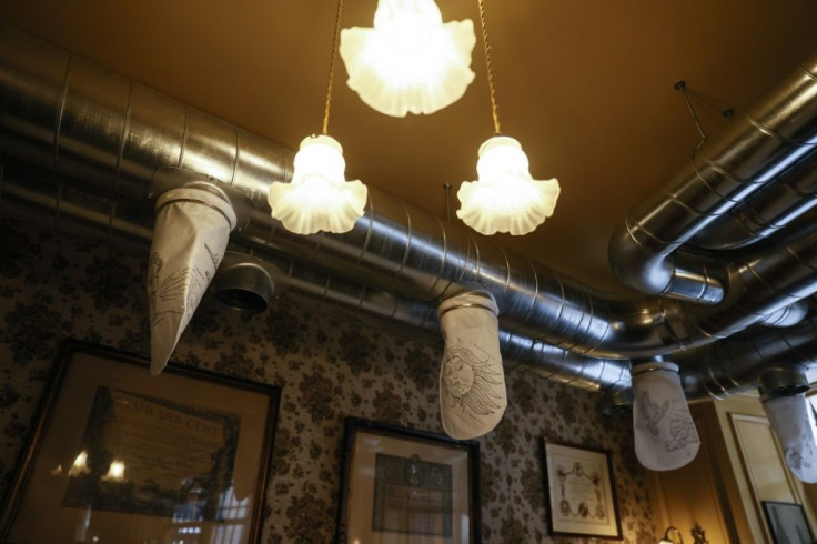 Large white air "socks" decorated with drawings of the gods and goddesses of the wind hang over every table