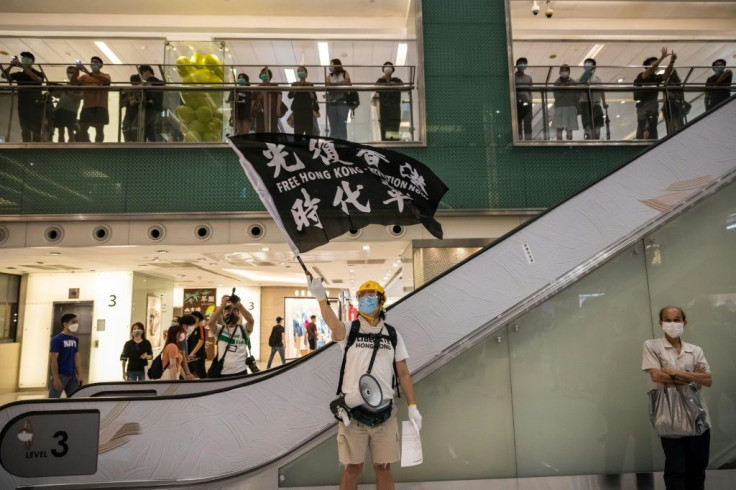 A protester holds a flag reading 'Free Hong Kong -- Revolution Now' in a shopping mall. Thousands took part in protests, defying a ban on public gatherings due to the coronavirus outbreak