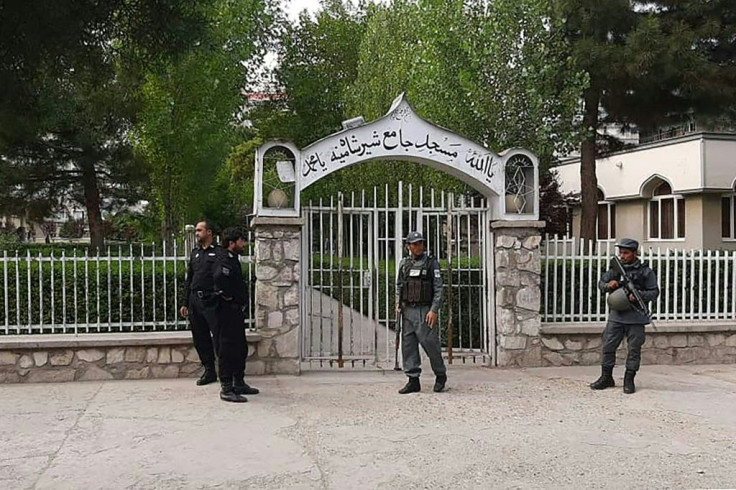 Police stand guard outside the Sher Shah Suri mosque in Kabul after a bomb blast killed four during Friday prayers