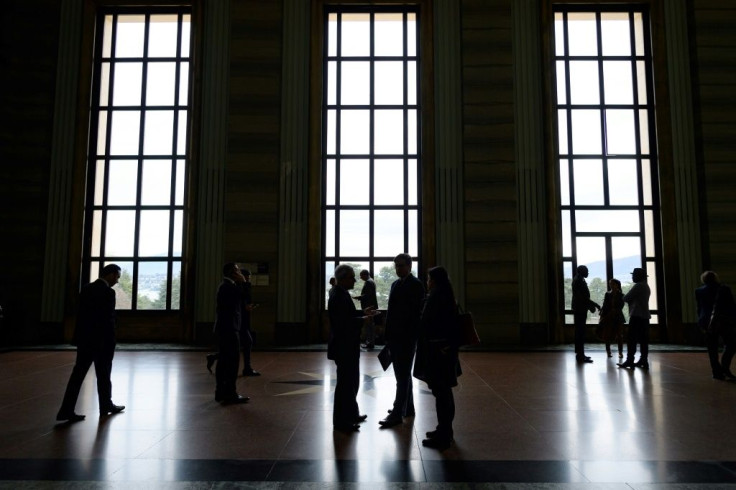 UN Human Rights Council delegates are seen in silhouette outside of the assembly hall during a session in Geneva in March 2020