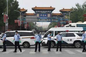 Police guard a Beijing market linked to a new coronavirus cluster