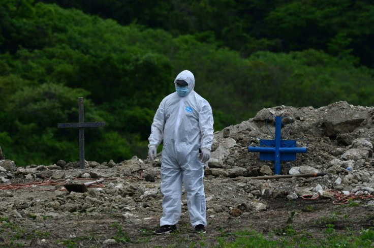 A man buries a relative, who died of coronavirus, in a Los Angeles cemetery -- the US remains the world's hardest-hit country