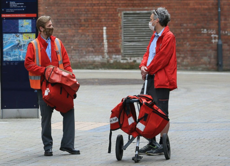 Two Royal Mail postal workers wearing coronavirus masks deliver mail in a deserted Leeds city centre