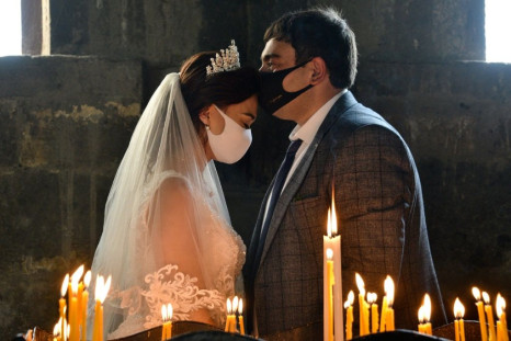 Conspiracy claims and alleged failure to take the virus threat seriously have seen cases incrase in Armenia -- here a bride and a bridegroom did don masks for their wedding at Saghmosavan near the capital