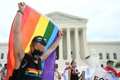 A person waves a rainbow flag in front of the US Supreme Court that released a decision saying federal law protects LGBTQ workers from discrimination