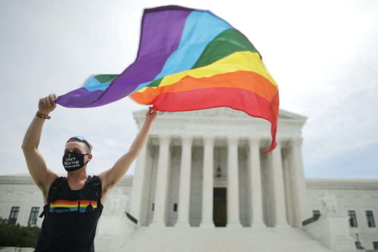Joseph Fons holds a Pride Flag in front of the US Supreme Court building after the court ruled that LGBT people cannot be disciplined or fired based on their sexual orientation