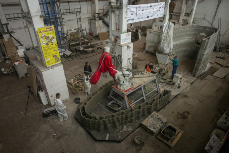 Workers check over the 3D construction, which is being printed from special concrete and is due to float down the river Vltava in August