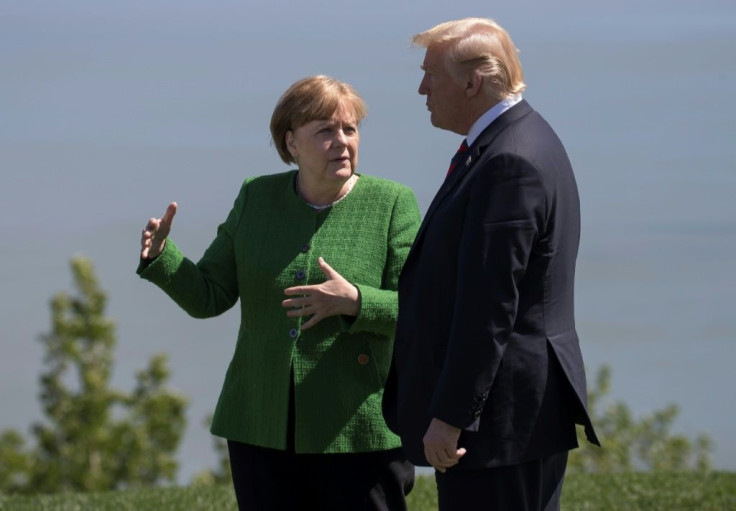 German Chancellor Angela Merkel confers with US President Donald Trump following a family photo session during the G7 Summit in La Malbaie, Canada in 2018