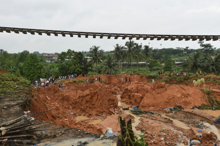 People stand near a suspended railway track