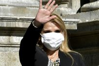 Bolivian interim President Jeanine Anez waves, while wearing a face mask, after attending a Corpus Christi procession at the Plaza de Armas in front of the government palace in La Paz, on June 11, 2020, amid the COVID-19 coronavirus pandemic