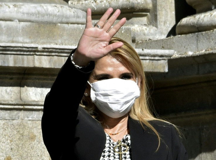 Bolivian interim President Jeanine Anez waves, while wearing a face mask, after attending a Corpus Christi procession at the Plaza de Armas in front of the government palace in La Paz, on June 11, 2020, amid the COVID-19 coronavirus pandemic