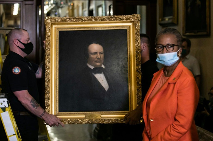 Workers remove the portrait of former US House speaker James Orr, who served in the Confederacy, from a wall in the US Capitol after current Speaker Nancy Pelosi ordered four such portraits removed because the men symbolized "grotesque racism"