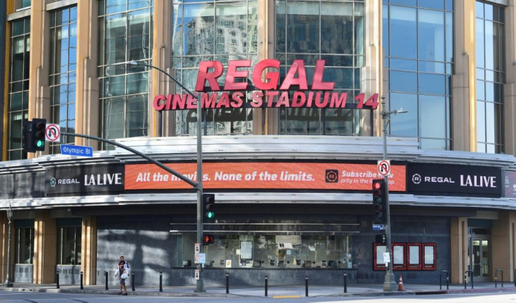 A lone pedestrian walks past a closed Regal Cinemas in Los Angeles, California on June 16, 2020.