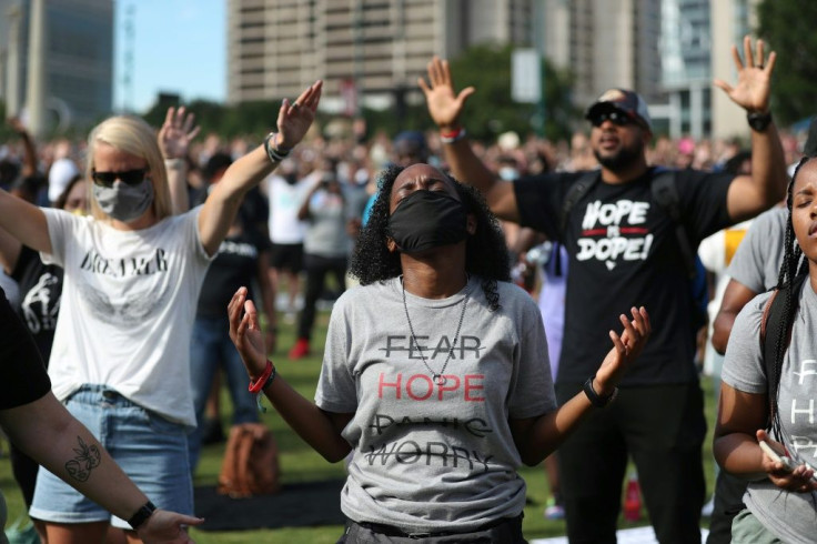 People praying during a Juneteenth event at Centennial Olympic Park in Atlanta, Georgia
