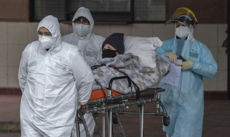 The toll thus increased by 3,069, officials said; pictured are health care staff transferring a patient with symptoms of COVID-19 to San Jose Hospital, in Santiago, on June 18, 2020
