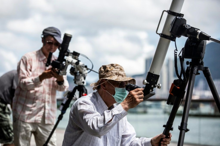 Skywatchers gathered on a Hong Kong waterfront to observe the spectacle