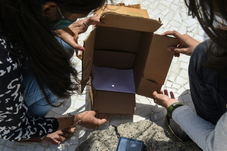 In India's Gujarat, members of a state science council watched the eclipse safely using a pinhole box