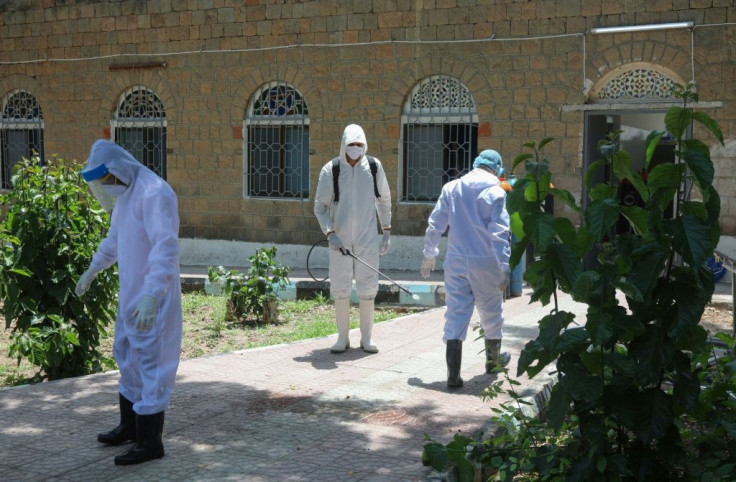 Yemeni medical workers disinfect their hazmat suits outside a quarantine centre for COVID-19 patients in Yemen's third city of Taez on June 21