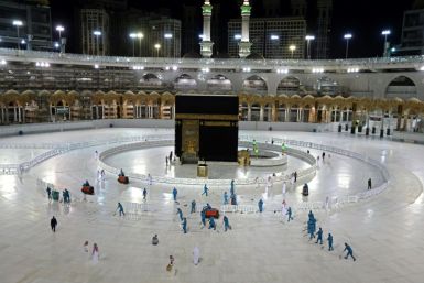 In this file photo taken on April 24, 2020, sanitation workers disinfect the area around the Kaaba in Mecca's Grand Mosque. On Monday Saudi Arabia said it will hold a 'limited' hajj this year due to the coronavirus pandemic