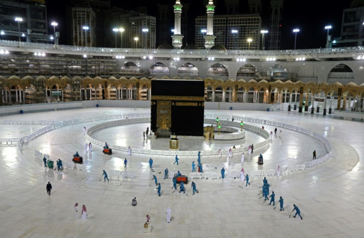 In this file photo taken on April 24, 2020, sanitation workers disinfect the area around the Kaaba in Mecca's Grand Mosque. On Monday Saudi Arabia said it will hold a 'limited' hajj this year due to the coronavirus pandemic