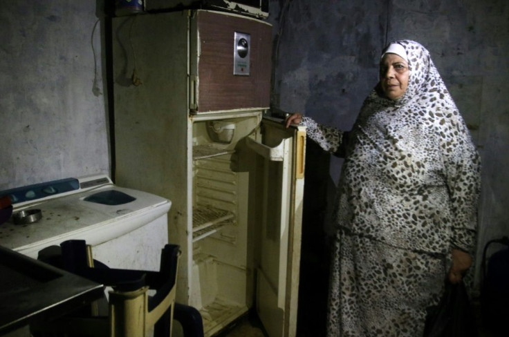 A Lebanese woman displays the content of her refrigerator at her apartment in the southern city of Sidon on June 16, 2020