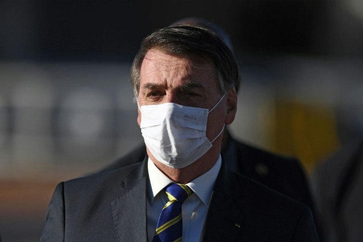 In this file photo taken on May 12, 2020 Brazilian President Jair Bolsonaro wears a face mask as he arrives at a flag-raising ceremony at the Alvorada Palace in Brasilia