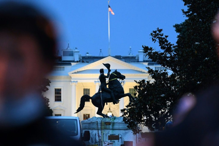 Police officers guard the statue of former US President Andrew Jackson just outside the White House after protesters tried to topple it