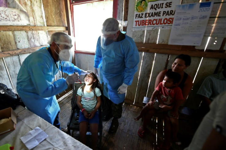 Doctors of the Brazilian Armed Forces check an indigenous child of the Mayoruna ethnic group, in the Cruzeirinho village, near Palmeiras do Javari, Amazonas state, northern Brazil, amid the COVID-19 pandemic