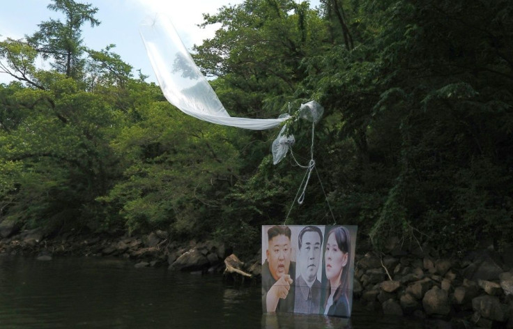 A balloon carrying a banner with portraits of North Korean leader Kim Jong Un (L), the late leader Kim Il Sung (C) and Kim Yo Jong, sister of Kim Jong Un, is caught on a tree after being launched by activists in Hongcheon
