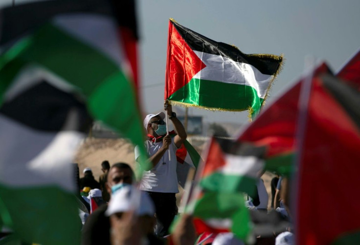 Palestinians wearing masks attend a rally to protest against Israel's plan to annex parts of the occupied West Bank, in Jericho on June 22