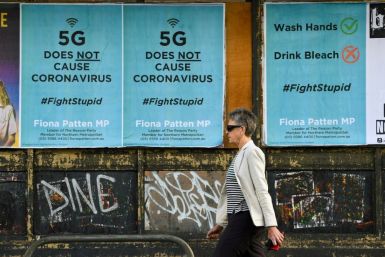 A pedestrian walks past public service announcement posters, negating a conspiracy that 5G telecommunications technology causes the coronavirus, in Melbourne, Australia