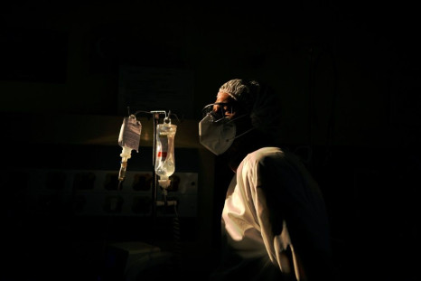A surgeon checks the intravenous drip of one of his COVID-19 patients, at the Oceanico hospital in Niteroi, Rio de Janeiro