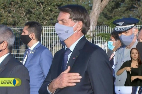Brazil's President Jair Bolsonaro has worn a face mask at an official event in Brasilia, following a ruling by a federal judge ordering him to wear one in public spaces.