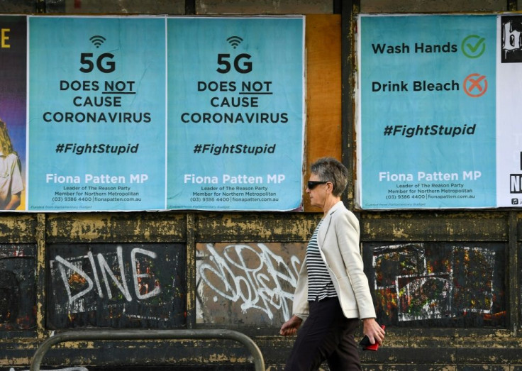 A pedestrian walks past public service announcement posters, negating a conspiracy that 5G telecommunications technology causes the coronavirus, in  Melbourne