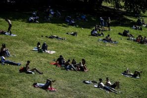 People enjoy the sun in a Paris park, but experts fear a surge in coronavirus infections