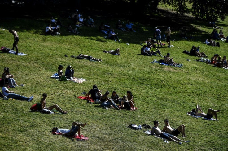 People enjoy the sun in a Paris park, but experts fear a surge in coronavirus infections