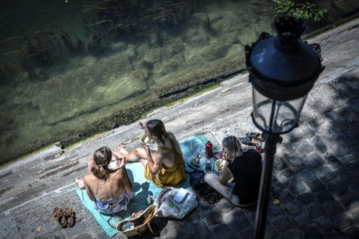 Europeans have thronged parks and rivers, as here on the banks of the River Seine in Paris, as the rising mercury announces the start of summer
